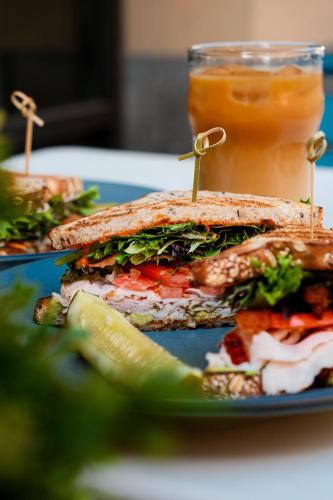 a sandwich on a plate with a pickle and a drink at Hotel Revival Baltimore in Baltimore