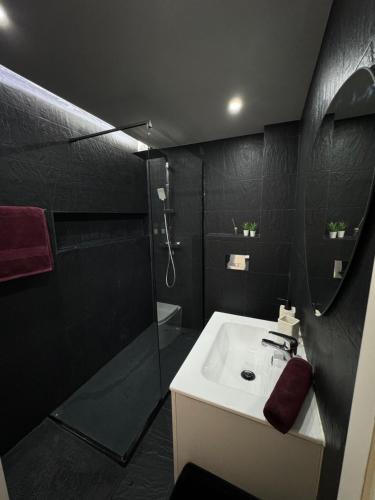 a black bathroom with a sink and a shower at Apartamento em Cascais in Cascais