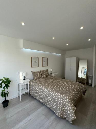 a bedroom with a bed and a table and a plant at Apartamento em Cascais in Cascais
