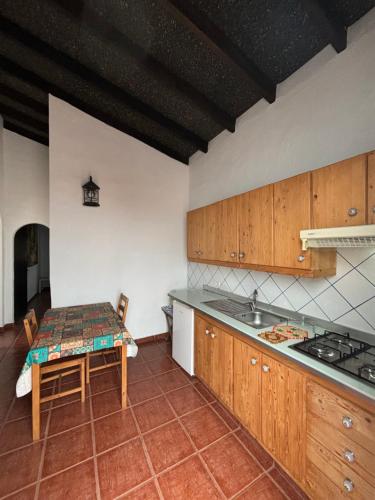 a kitchen with a table and a sink in it at Apartamentos y Habitaciones Villa Marina in La Caleta