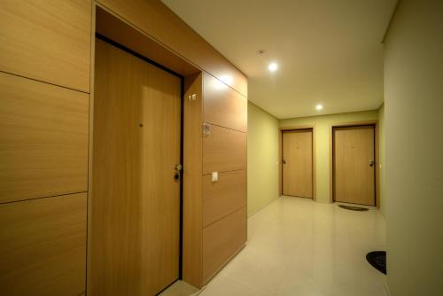 a hallway with wooden doors and white tile floors at Apartamento Lux 1882 in Figueira da Foz