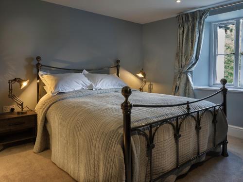 a bedroom with a bed with two lamps and a window at Millslade Country House in Lynton