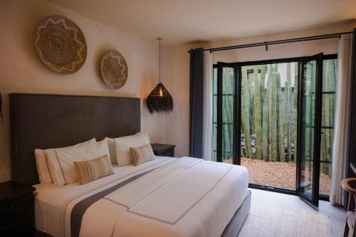 a bedroom with a large bed and a large window at Hotel Amatte San Miguel de Allende in San Miguel de Allende