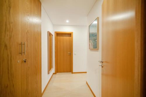 a hallway with two wooden doors and a hallway at Apartamento Lux 1882 in Figueira da Foz