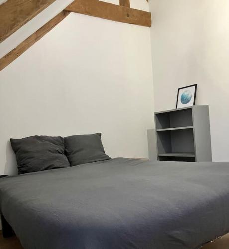 - une chambre avec un grand lit et une étagère dans l'établissement Longère proche de la mer, à Guidel