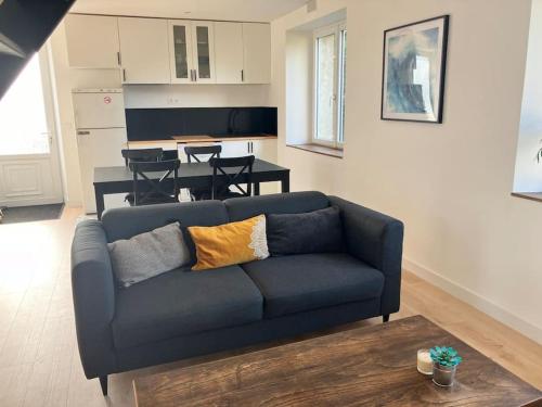 un salon avec un canapé bleu et une cuisine dans l'établissement Longère proche de la mer, à Guidel