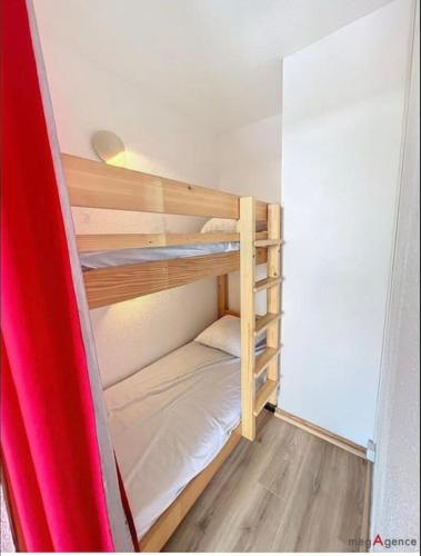 Cette chambre comprend 2 lits superposés et une planche de surf. dans l'établissement Le Courchevel à Grèsse, à Gresse-en-Vercors