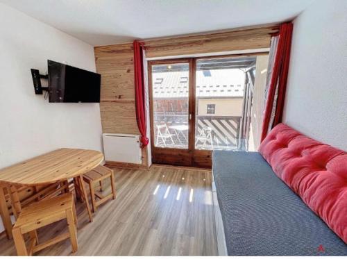 een woonkamer met een rode bank en een tafel bij Le Courchevel à Grèsse in Gresse-en-Vercors