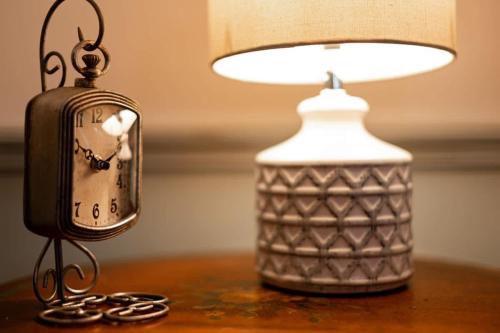 a clock sitting on a table next to a lamp at The Mohawk Valley House - 4 suite boutique hotel renamed in Bellmead