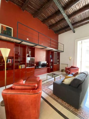 - un salon avec des murs rouges, un canapé et des chaises dans l'établissement Casa Orlanda, à Naples