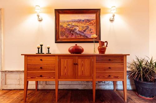 a wooden dresser in a room with a painting on the wall at Hudson upstairs suite - The Mohawk Valley House in Bellmead