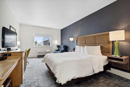 a hotel room with a bed and a flat screen tv at Sonesta Essential Vacaville Napa Valley in Vacaville