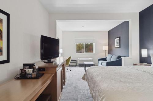 a hotel room with a bed and a flat screen tv at Sonesta Essential Vacaville Napa Valley in Vacaville