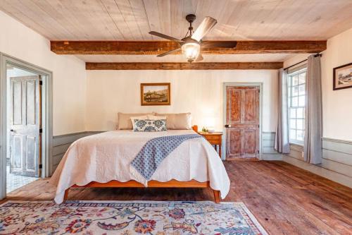 BellmeadにあるErie Canal Suite - The Mohawk Valley Houseのベッドと天井扇風機のある寝室