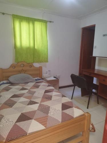 a bedroom with a bed and a desk and a piano at Hostal Venecia in Arica