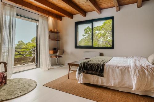 une chambre avec un lit, un bureau et une fenêtre dans l'établissement Domaine Kalliste Porto Vecchio, à Porto-Vecchio