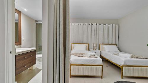 zwei Betten in einem Zimmer mit Bad in der Unterkunft Absolute Beach Bliss, Chic & Expansive Retreat in Sunny Isles Beach