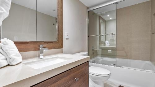ein Badezimmer mit Waschbecken, Toilette und Dusche in der Unterkunft Absolute Beach Bliss, Chic & Expansive Retreat in Sunny Isles Beach