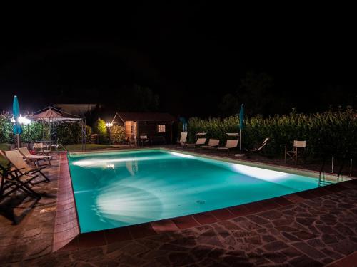 uma piscina iluminada à noite em Belvilla by OYO Villa Lonanno em Pratovecchio