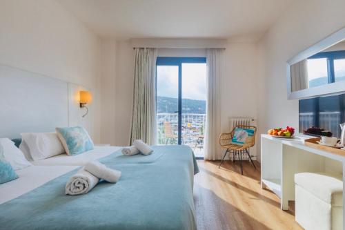 a hotel room with a bed with towels on it at Hotel Miramar in Port de Soller