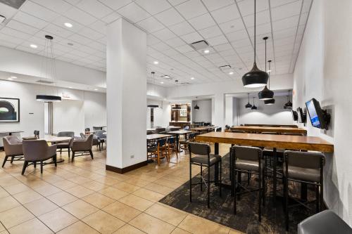 a restaurant with a bar and tables and chairs at Hyatt Place Chicago O'Hare Airport in Rosemont