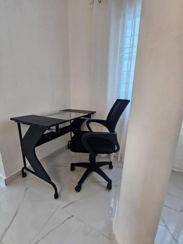 a black desk and a chair in a room at vista a toda la ciudad y montaña in San Felipe de Puerto Plata