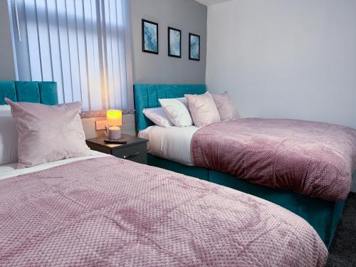 two beds sitting next to each other in a bedroom at Newport En-suite Rooms Middlesbrough Centre in Middlesbrough