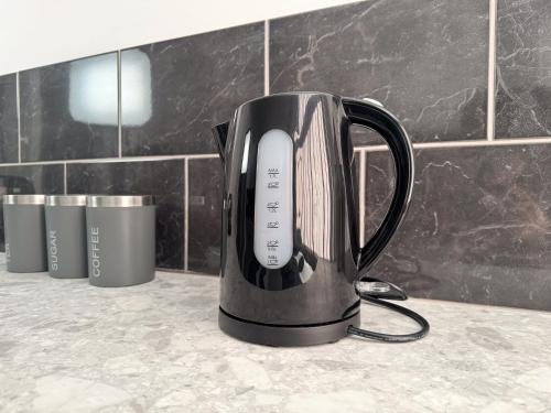 a black electric kettle sitting on a counter at Newport En-suite Rooms Middlesbrough Centre in Middlesbrough