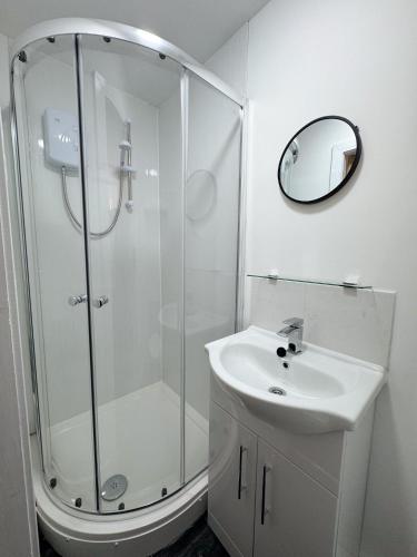 a white bathroom with a shower and a sink at Newport En-suite Rooms Middlesbrough Centre in Middlesbrough
