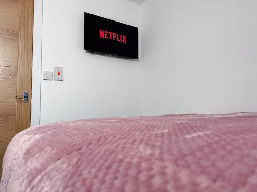 a bedroom with a bed and a tv on the wall at Newport En-suite Rooms Middlesbrough Centre in Middlesbrough