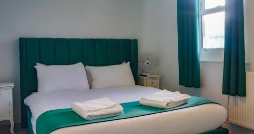 a bed with two towels sitting on top of it at The Pier Hotel in Eastbourne