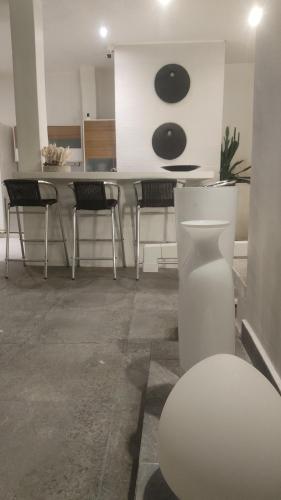 a room with chairs and a kitchen with a counter at Rincón del mar Veleros Hotel in San Onofre