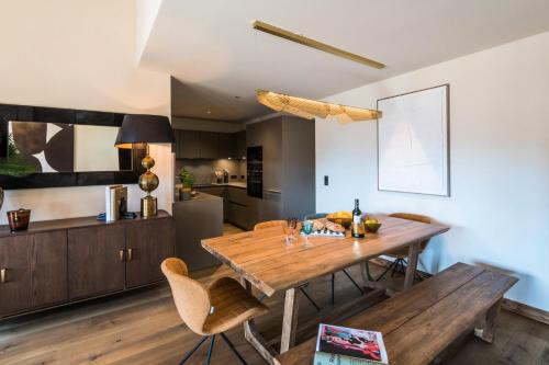 une cuisine et une salle à manger avec une table et des chaises en bois dans l'établissement Résidence Le Stella - Magnifique appartement haut de gamme MAE-0911, aux Gets