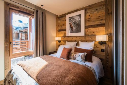 une chambre avec un grand lit et une fenêtre dans l'établissement Résidence Le Stella - Magnifique appartement haut de gamme MAE-0911, aux Gets