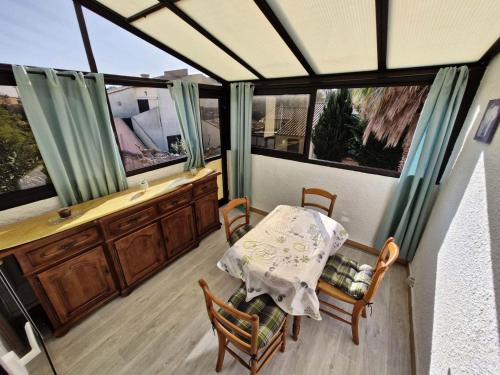 une véranda avec une table et des chaises dans l'établissement Résidence Helios - APPT T2 CAB OU MEZZ 5 couchages PORT LEUCATE MAE-1851, à Leucate