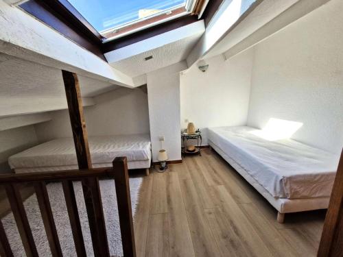 - une chambre avec 2 lits et une lucarne dans l'établissement Résidence Helios - APPT T2 CAB OU MEZZ 5 couchages PORT LEUCATE MAE-1851, à Leucate