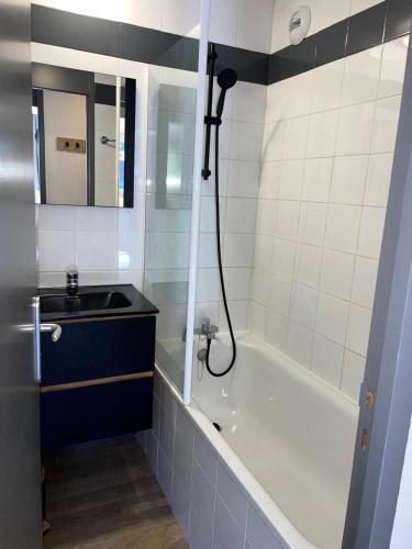 une salle de bain avec un lavabo et une baignoire dans l'établissement Résidence Ellebore - Appartement cosy et lumineux coeur de station MAE-5791, à Aime La Plagne
