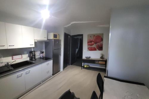 a kitchen with white cabinets and a counter top at le palierou in Paulhe