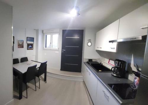 a kitchen with a table and a black door at le palierou in Paulhe