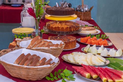 a table topped with lots of different types of food at Pousada Aysú Maresias in Maresias