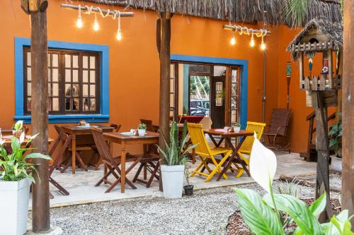 a restaurant with tables and chairs in an orange building at Pousada Aysú Maresias in Maresias