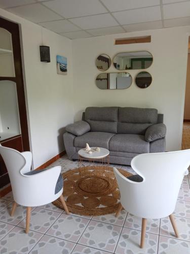 a living room with a couch and a table and chairs at Ti'bulle de sérénité in Rivière-Salée
