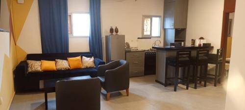 ein Wohnzimmer mit Sofa und eine Küche in der Unterkunft Lodje in Douala