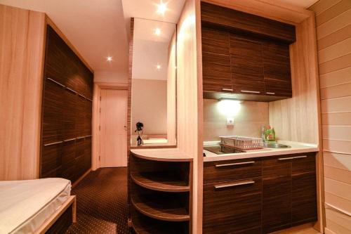una pequeña cocina con fregadero y una cama en una habitación en Apartments Konaci Centar, en Kopaonik