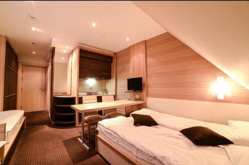 Una habitación de hotel con dos camas y un escritorio. en Apartments Konaci Centar, en Kopaonik