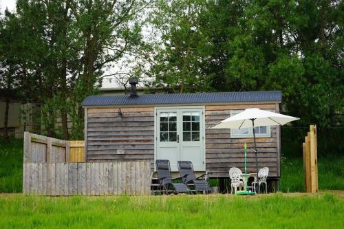 a small cabin with chairs and an umbrella at Jasmine Hut in Bristol