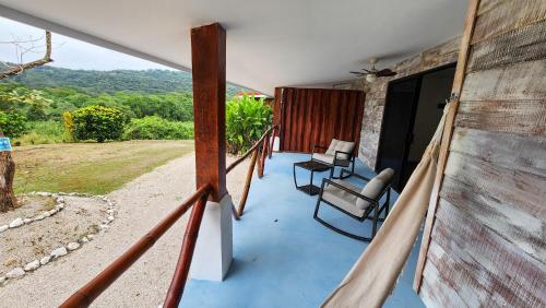 a porch of a house with two chairs on it at La Puesta del Sol B&B in Carrillo