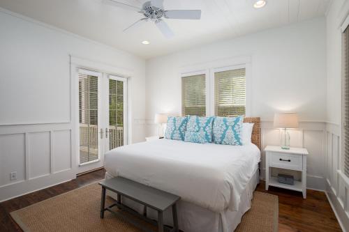 Camp District of WaterColor - Outdoor TV and Porches في شاطئ سانتا روزا: غرفة نوم بيضاء مع سرير ومروحة سقف