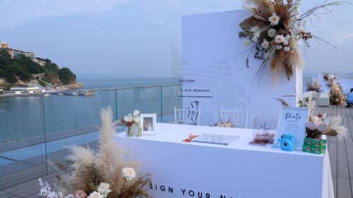 a white table with flowers and a view of the ocean at Intercontinental Shenzhen Dameisha Resort by IHG in Shenzhen