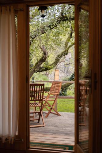 a door to a porch with two chairs and a tree at Glamping Dragonja River in Šmarje